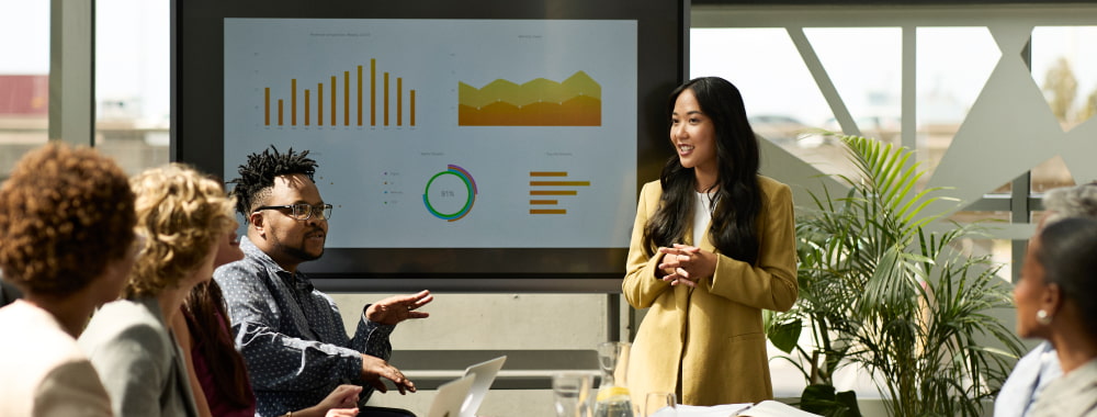 Réunion avec écran affichant des graphiques variés.